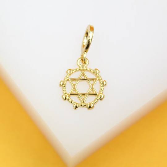 A gold Star of David pendant rests on a clean white display surface.