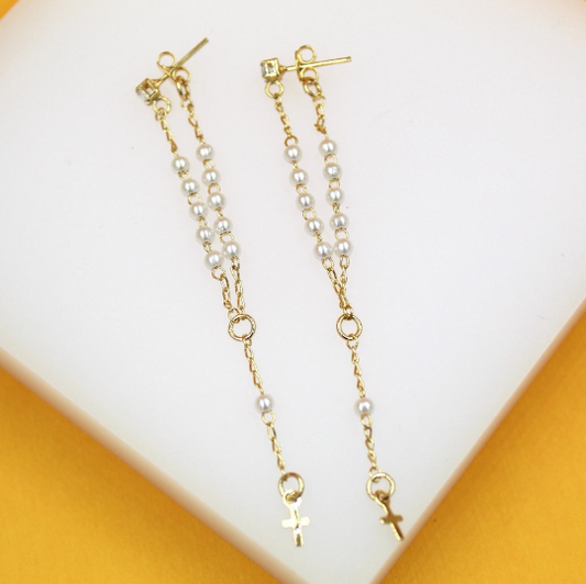 A pair of elegant gold chain earrings features dangling white pearls and a delicate cross charm.