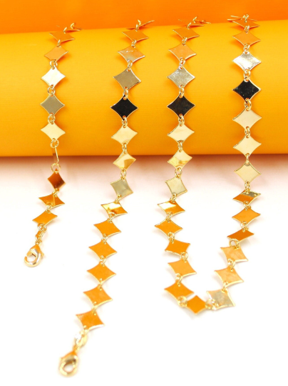 Four delicate gold rhombus-shaped link chain necklaces are displayed against a vibrant orange and white background.
