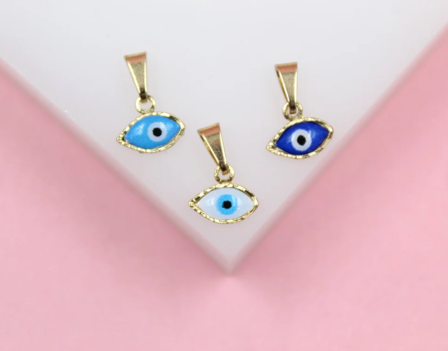 Three gold evil eye charms in light blue, dark blue, and white display detailed enamel work against a pink and white background.