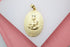 A gold oval pendant displays a textured depiction of the Virgin Mary with a sparkling diamond accent.