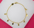 A delicate gold chain bracelet features hanging heart charms displayed on a white and pink background.