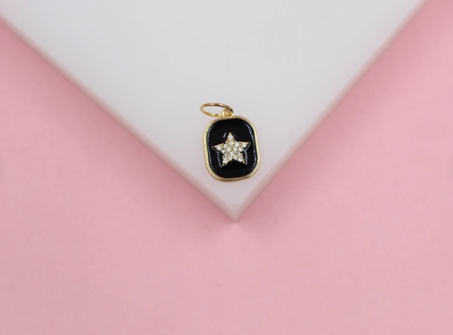 A gold star pendant with sparkling cubic zirconia rests on a white display against a pink background.