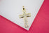 A sparkling diamond cross pendant rests elegantly on a white and pink display surface.