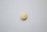 A small gold pendant coin rests flat against a clean white background.