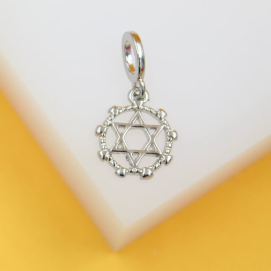 A silver Star of David pendant hangs against a clean white and yellow background.