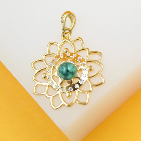 A gold mandala pendant features an intricate lotus flower design accented with sparkling cubic zirconia and a central malachite gemstone.