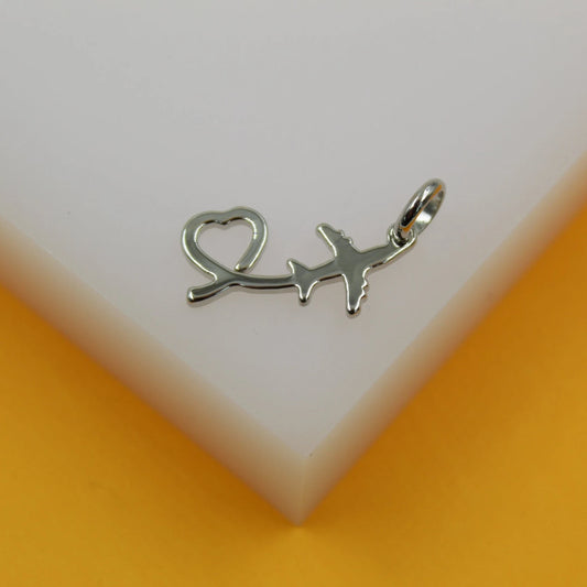 A silver airplane pendant featuring an integrated heart shape rests on a white and yellow display surface.