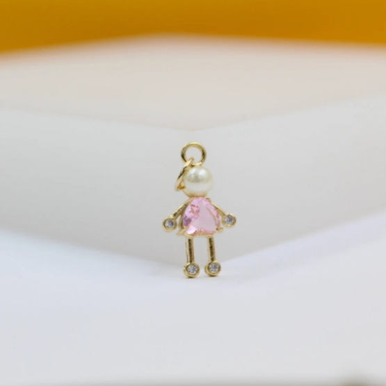 A gold girl pendant necklace features a pearl head and a pink gemstone dress adorned with tiny sparkling stones.