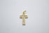 A sparkling diamond-encrusted gold cross pendant rests against a plain grey background.
