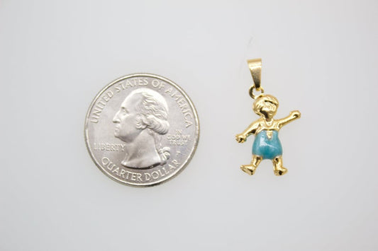 A gold boy charm pendant with blue enamel shorts rests next to a US quarter for size comparison.