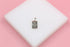 A silver celestial pendant featuring a heart, moon, and stars rests on a white display block against a pink background.
