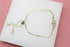 A gold snake slider bracelet with sparkling crystal accents rests on a white display surface.