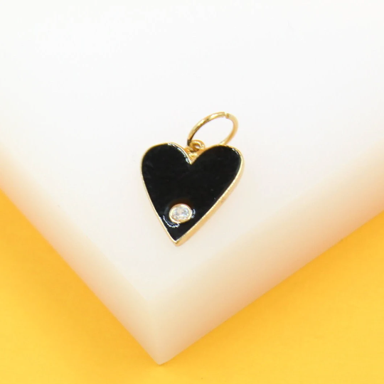 A gold heart-shaped pendant features glossy black enamel and a sparkling cubic zirconia stone.