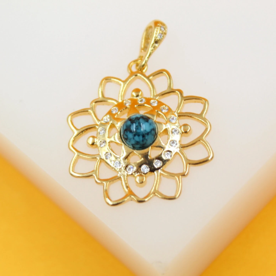 A gold mandala flower pendant features a central turquoise gemstone surrounded by sparkling cubic zirconia crystals.