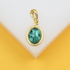 A gold pendant features an oval-shaped turquoise gemstone with intricate black veining, displayed against a neutral background.