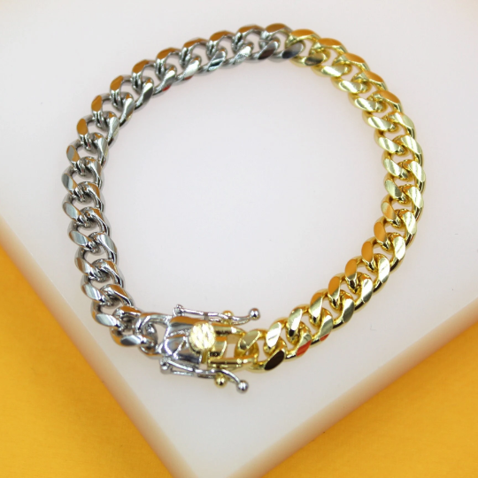 A two-tone cuban link bracelet rests on a white display surface with a secure box clasp closure.