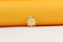 A gold sunburst pendant rests against a bright yellow and white background.
