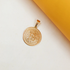 A shiny gold Bitcoin pendant rests against a white and yellow background.