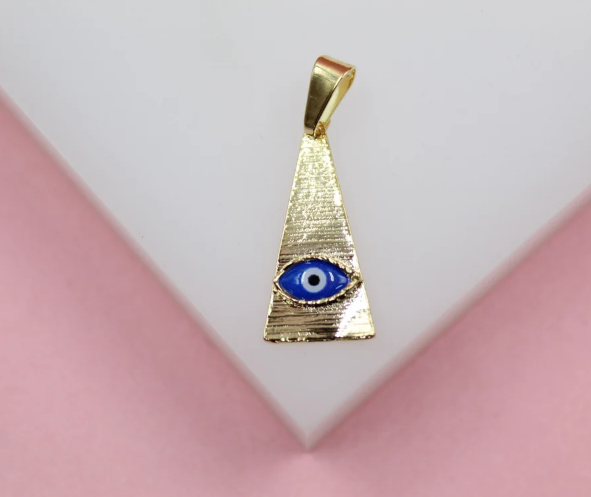 A textured gold triangle pendant featuring a blue and white evil eye symbol rests on a white display surface.