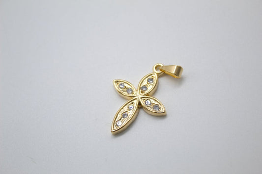 A gold cross pendant with sparkling crystal stones rests on a plain white background.