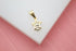 A sparkling diamond sparkles within a delicate gold star pendant resting on a white surface.