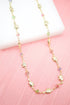A delicate gold chain necklace features alternating gold elephant charms and colorful crystal beads against a soft pink and white background.