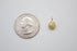 A tiny gold pave-set CZ circle charm sits next to a US quarter for size comparison.