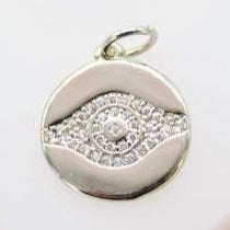 A gleaming silver evil eye pendant sparkles with embedded cubic zirconia stones against a neutral background.