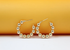 Two gold beaded hoop earrings rest neatly against a vibrant orange and white background.