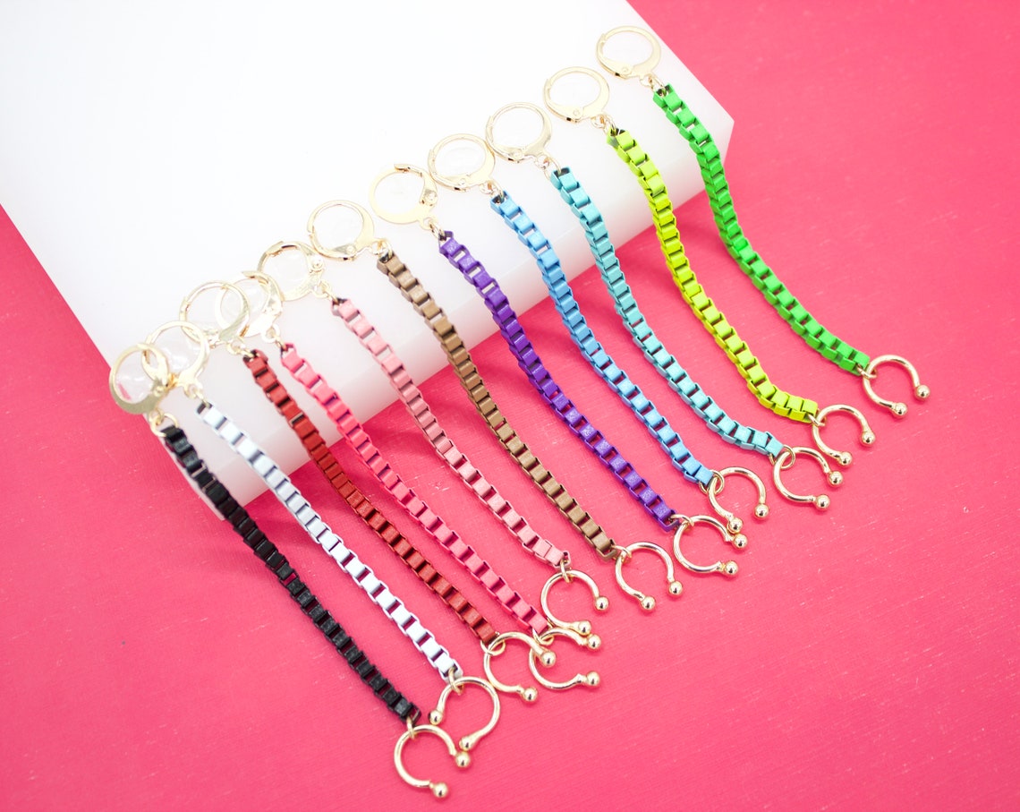 A colorful collection of ten beaded chain attachments featuring golden rings and clasps is neatly displayed on a white and pink background.