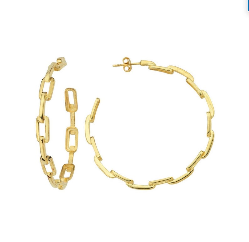 A pair of gold chain-link hoop earrings displays an interlocking link design against a plain white background.