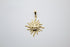 A polished gold sun pendant featuring a smiling face and wavy rays hangs against a plain white background.