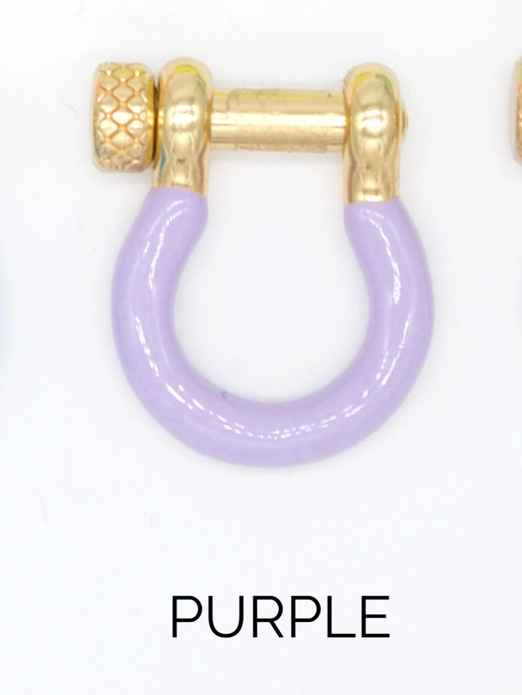 A gold horseshoe-shaped earring features a lavender enamel coating and a textured screw closure.