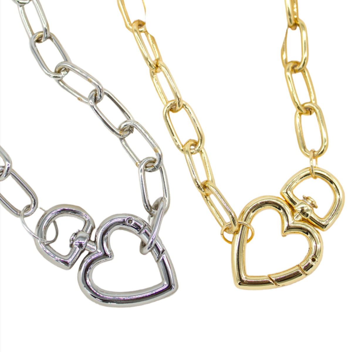 Two chunky chain necklaces, one silver and one gold, feature heart-shaped clasp pendants against a white background.