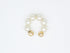 A gold pearl ear cuff rests on a clean white background.