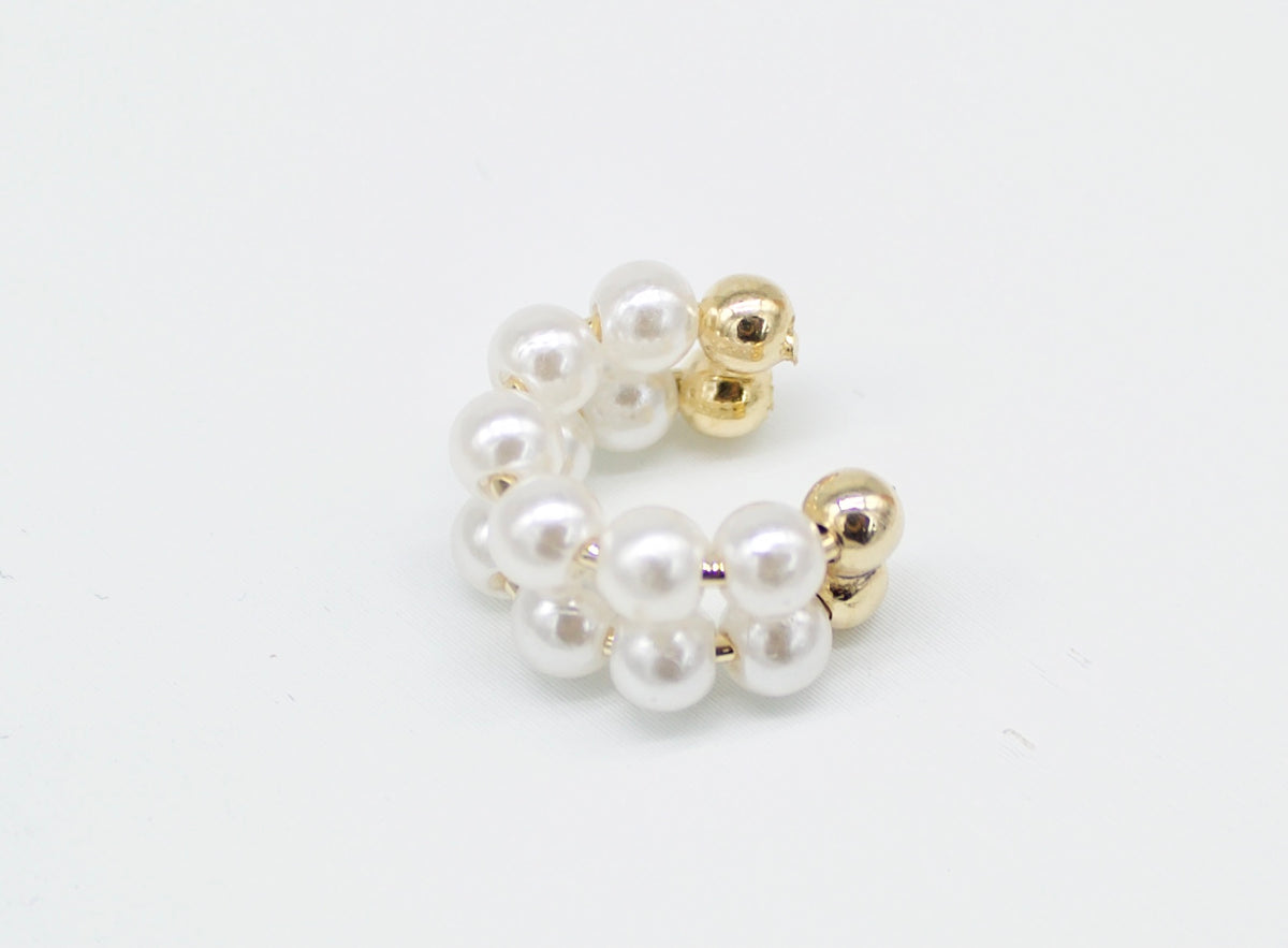 A stylish pearl ear cuff features a double band of white faux pearls accented with polished gold beads against a clean white background.