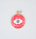 A round gold evil eye pendant with vibrant pink enamel features a white and blue eye symbol at the center.
