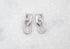 A pair of sparkling silver pave-set huggie hoop earrings featuring interlocking links rests against a white marble surface.