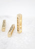 Three vertical gold bar charms with engraved words Faith, Love, and Action rest upright on a white surface.