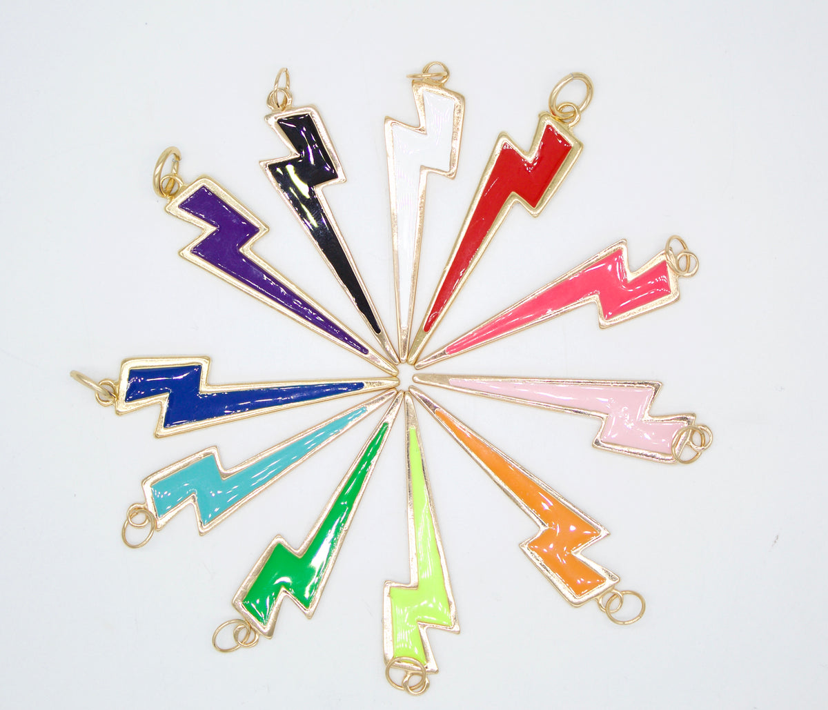 A colorful assortment of enamel lightning bolt charms featuring gold outlines arranged in a circle against a white background.