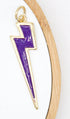 A gold-trimmed, purple enamel lightning bolt pendant hangs vertically against a white background inside a wooden display hoop.