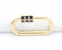 A gold oval charm connector features a black enamel grid pattern on its clasp against a white background.