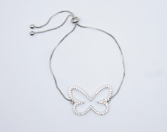 A silver adjustable bolo bracelet features a sparkling crystal-encrusted butterfly charm resting against a plain white background.