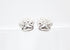 A pair of sterling silver paw print stud earrings rest against a clean white background.