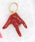 A glossy red enamel "I love you" hand sign charm dangles from a gold jump ring.
