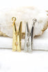 Two metallic clothespin charms, one gold and one silver, rest upright on a white crystal geode surface.