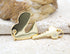 A shiny gold lock and key pendant set rests on a textured stone surface.