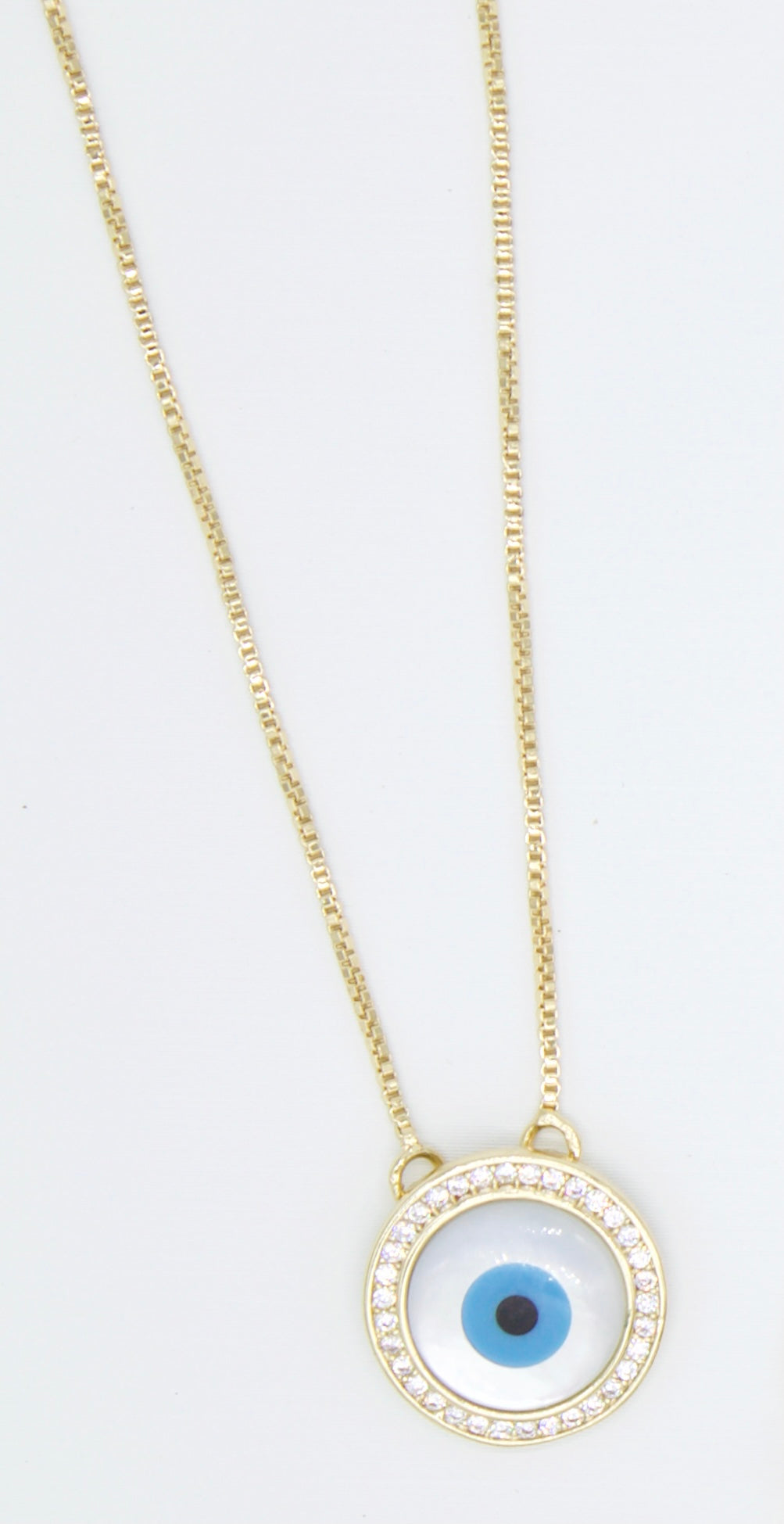A delicate gold chain holds a round evil eye pendant sparkling with pavé stones.