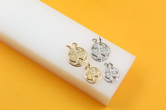 Four gold and silver "Best Friends" split heart pendant charms rest on a white block against a bright yellow background.
